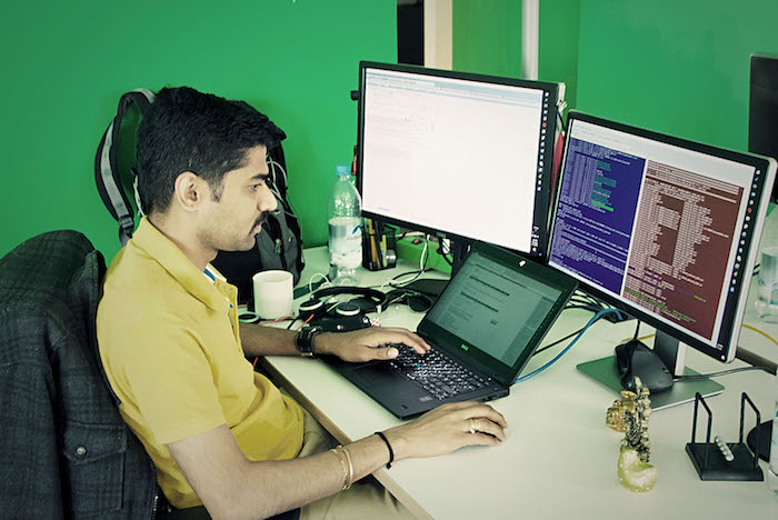 Neos IT Services, working environment, employee in front of two screens